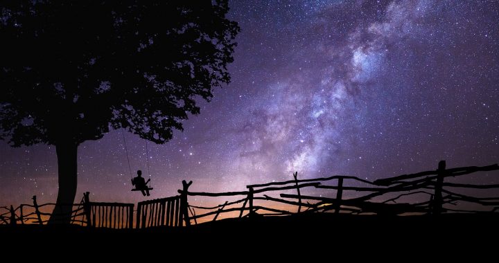 child on a swing looking at starry night